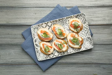 Wandcirkels plexiglas Tasty canapes with salmon, cucumber, cream cheese and dill on wooden table, top view © New Africa