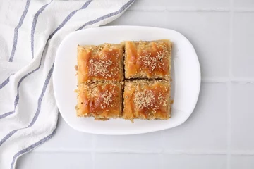  Eastern sweets. Pieces of tasty baklava on white tiled table, top view © New Africa