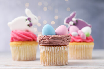 Tasty decorated Easter cupcakes on wooden table