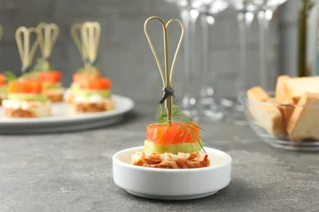 Tuinposter Tasty canape with salmon, cucumber, bread and cream cheese on grey table, closeup © New Africa