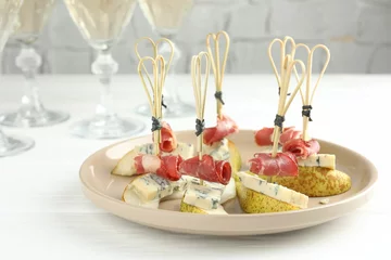 Fotobehang Tasty canapes with pears, blue cheese and prosciutto on white wooden table, closeup © New Africa