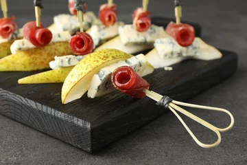 Fotobehang Tasty canapes with pears, blue cheese and prosciutto on grey table, closeup © New Africa