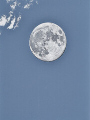 A blue sky with a white moon in the middle