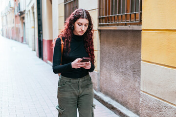 Traveler using her mobile phone's GPS to navigate the streets of the city she is visiting