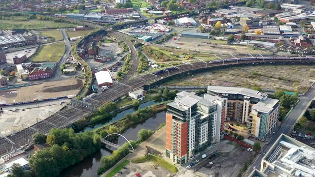 Aerial footage of the town centre of Leeds in West Yorkshire UK, showing trains traveling in to the train station with trains going in to the station along the canal.
