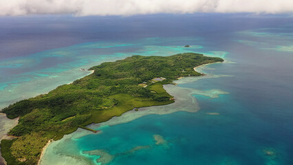 Fiji Islands. Turquoise waters of ocean wash island covered tropical vegetation. Travel concept.