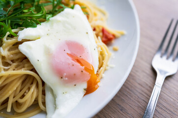 Italian spaghetti del poverello (Poor Man's Spaghetti), spaghetti pasta mixed with a lightly fried egg. Egg and cheese pasta, healthy food