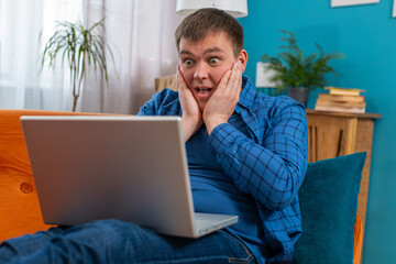 Surprised amazed man guy using laptop computer, receive mail good news message, wow shocked by...
