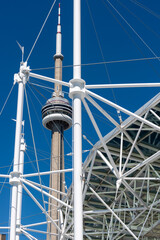 Fototapeta premium CN Tower viewed through Harbourfront Centre Concert Stage framework, an event venue, in Toronto, Canada