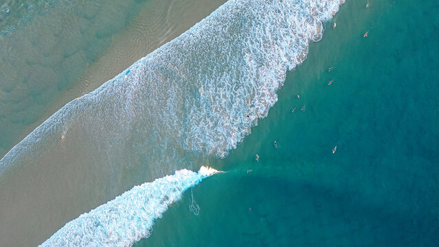 Top view of the ocean beach. Calm seascape with white foam and sand. Travel and leisure concept.