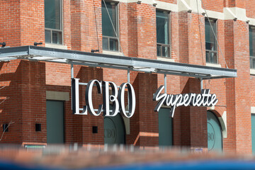 Fototapeta premium exterior building and sign of LCBO, a liquor store chain and Superette, a cannabis store, located at 49 Spadina Avenue in Toronto, Canada