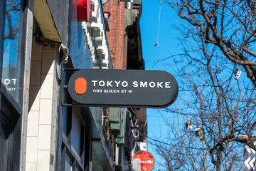 Fototapeta premium exterior projecting sign of Tokyo Smoke, a cannabis store, located at 1180 Queen Street West in Toronto, Canada