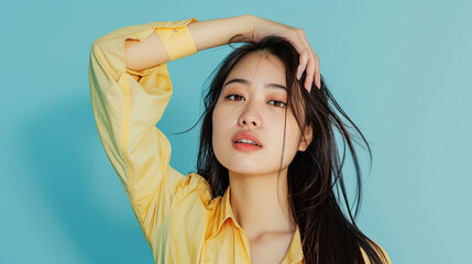 Image of young Asian woman posing on pastel blue background