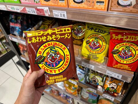 PENANG, MALAYSIA - MAY 2, 2023: Hand holding Japanese brand Hakodate lucky pierrot miso noodle paste with grocery store shelf background.