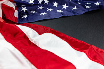 American flag on the folded to the left side of  background of black texture 