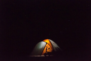 Tent in the desert in total darkness showing shadow from bicycle handlebars due to internal lighting