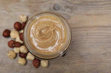 Tasty hazelnut nut paste in jar on table, top view. Space for text