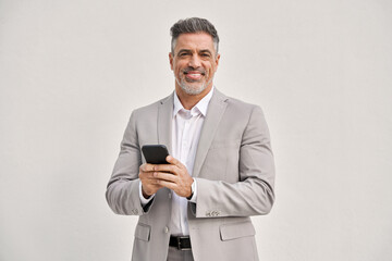 Portrait of happy middle aged business man wearing suit using mobile cell phone looking at camera isolated on white. Smiling older businessman holding cellphone using banking finance app on smartphone - 783153839