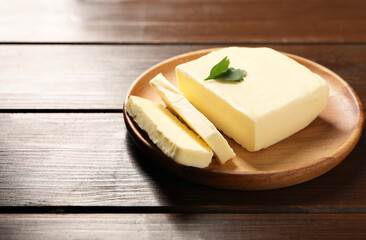 Cut tasty butter with parsley on wooden table