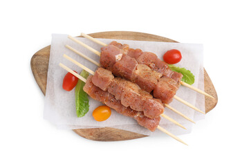 Wooden skewers with cut raw marinated meat isolated on white, top view
