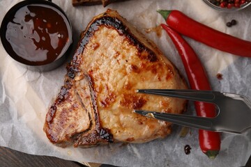 Tasty grilled meat, chili and marinade on wooden table, top view