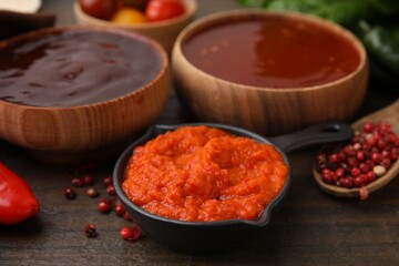 Different marinades and products on wooden table, closeup view