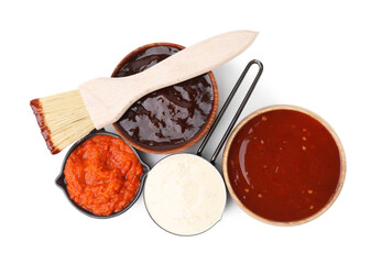 Different marinades and basting brush isolated on white, top view