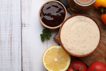 Different fresh marinades and ingredients on white wooden table, flat lay. Space for text