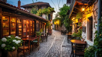 Fotobehang An old tavern on an old narrow paved street in a lovely old town in the evening © Adrian Grosu