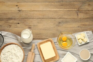Flat lay composition with fresh butter and other products on wooden table. Space for text