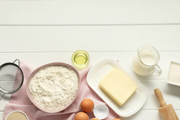 Flat lay composition with fresh butter and other products on white wooden table. Space for text