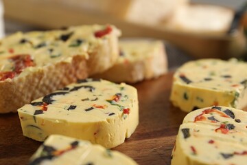 Tasty butter with olives, chili pepper and parsley on wooden table, closeup
