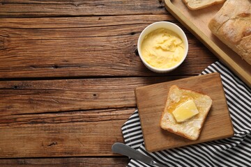 Melting butter, toast and knife on wooden table, top view. Space for text