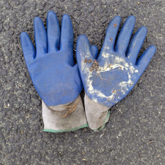 Blue protective work gloves on asphalt