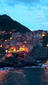 Houses on cliff in Manarola village popular tourist destination in Cinque Terre National Park a UNESCO World Heritage Site, Liguria, Italy in the evening. Camera panning