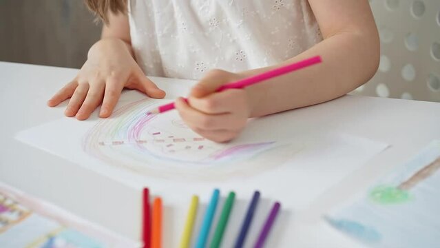 Close-up of a child's hands coloring a drawing with bright pencils. Young girl engaging in colorful artistic drawing and coloring activity using pencils. Enhancing creativity. Imagination