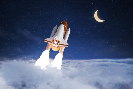 Space shuttle rocket successfully takes off through the clouds towards the moon in the starry sky, creative idea. Journey to the moon, concept. Rocket lift off and launch