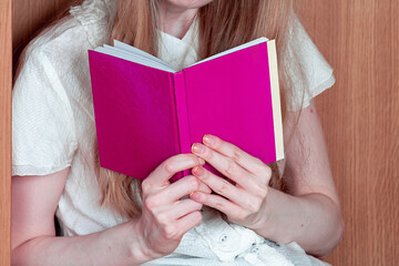 Woman reading from the pages of an open book - 783185093