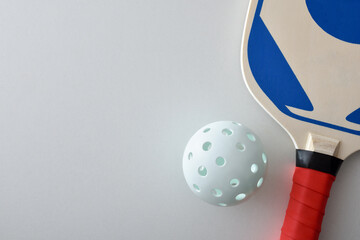 Detail of pickleball racket and ball isolated on white table
