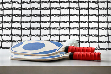 Pickleball rackets and balls on white table and background network