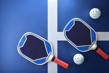 Blue and red pickleball paddles isolated on playing court