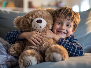 A high-quality photo captures a young boy happily playing on the couch, embracing a stuffed teddy bear with joy.