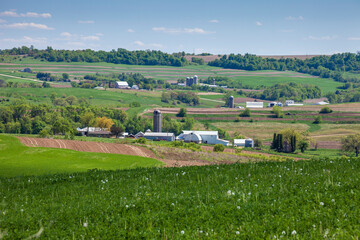 Farms and fields on rolling hills in the Iowa countryside during spring