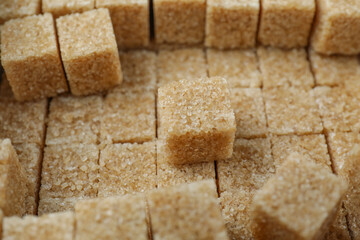 Brown sugar cubes as background, closeup view