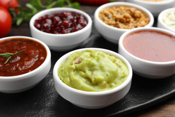 Different tasty sauces in bowls on table, closeup