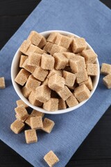 Brown sugar cubes on black table, flat lay
