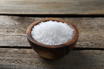 Fototapeta na wymiar Organic salt in bowl on wooden table, closeup