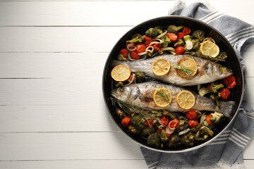 Baked fish with vegetables, rosemary and lemon on white wooden table, top view. Space for text