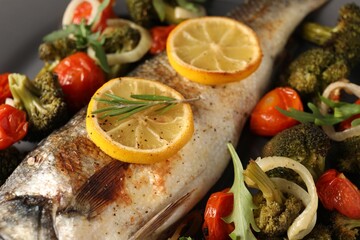 Baked fish with vegetables, rosemary and lemon, closeup