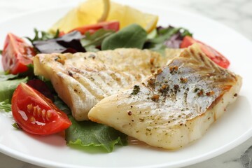 Tasty cod cooked with salad on table, closeup